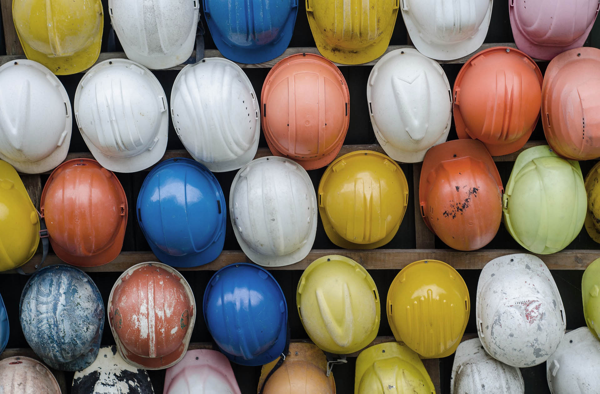 Hard hats hanging in rows.